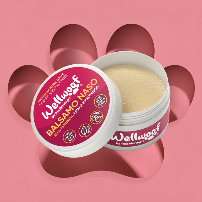 Balsamo Naso Wellwoof by RedMoringa, vasetto aperto su sfondo rosa con zampa: crema per il naso screpolato del cane