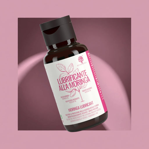 RedMoringa natural Moringa intimate lubricant oil with almond and rosehip oil, bottle on a pink background