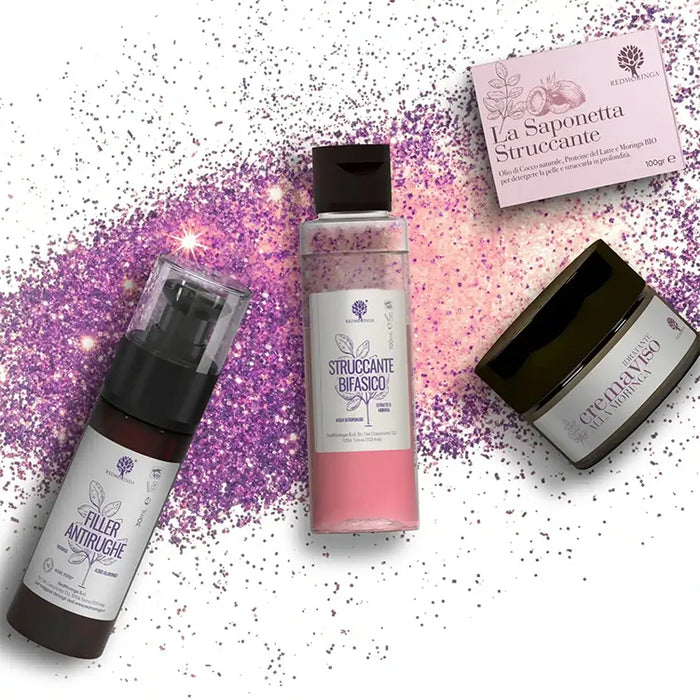 Los cuatro cosméticos del Set Regalo Moringa Beauty RedMoringa sobre una lluvia de purpurina morada